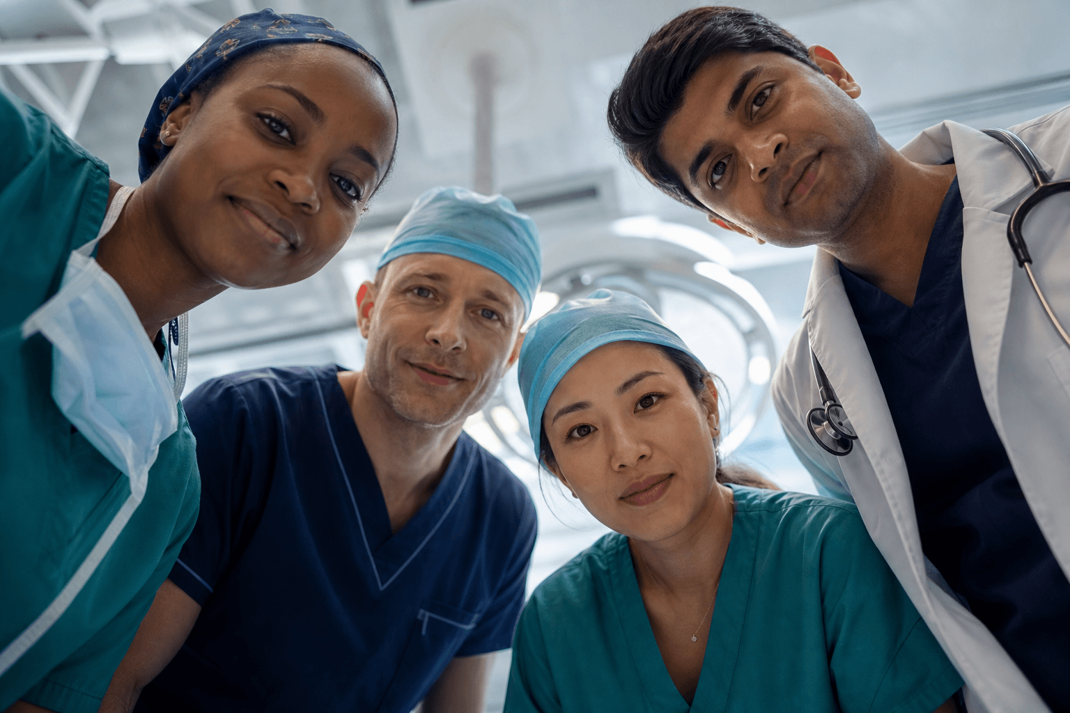 A mixed-race team of doctors and nurses looking down with care in a hospital setting